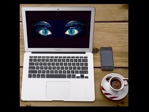 Laptop with watching eyes on the screen, symbolizing hidden malware on Mac